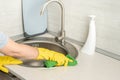 Cleaning. woman gloves hands cleaning kitchen sink. Cleaning home table, sanitizing kitchen table, surface with disinfectant spray Royalty Free Stock Photo