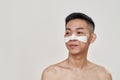 Deep cleansing. Portrait of shirtless young asian man with mask applied on his face looking away isolated over white Royalty Free Stock Photo