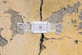 Deep crack in a damaged old plaster wall with plastic mechanical crack meter designed to measure movement across surface cracks