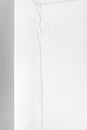 Deep crack in the white wall from floor to ceiling. Problems of construction and repair Royalty Free Stock Photo