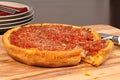 Deep dish pizza with a piece cut out Royalty Free Stock Photo