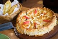 Deep dish seafood pizza Chicago style on the table with garlic bread on the side Royalty Free Stock Photo