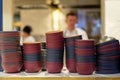 Deep dishes stacked in piles on a kitchen counter in a fast food restaurant. Cooks on a blurred background