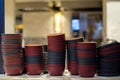 Deep dishes stacked in piles on a kitchen counter in a fast food restaurant. Cooks on a blurred background