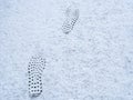 Deep footprints on white winter snow