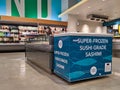 Deep fridge filled with fresh cuts of fish for cooking, sushi, and poke bowls inside a Whole Foods store