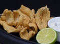 Deep fried anchovies with tartar sauce and lime wedge in a serving dish Royalty Free Stock Photo