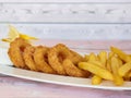 DEEP FRIED CALAMARI SQUID RINGS With French Fries served in dish isolated on table closeup top view of grilled seafood Royalty Free Stock Photo