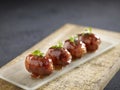 Deep-fried Cheese Bacon Roll served in a dish isolated on wooden board side view dark background Royalty Free Stock Photo