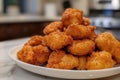 Deep fried chicken nuggets on white plate, panoramic shot