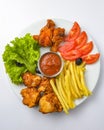 Deep fried chicken platter, chicken wings, nuggets, french fries and fresh green salad with dip tomato sauce Royalty Free Stock Photo