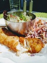 Deep fried cod fish with coleslaw and green salad on the side