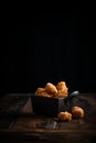 Deep fried dough stick in a black bowl on a wooden background. Royalty Free Stock Photo