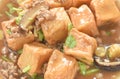 Deep fried fish tofu with chop pork topping slice mushroom in sweet and sour gravy sauce on plate Royalty Free Stock Photo