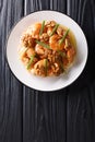 Deep fried honey prawns with caramelized walnuts and spring onions close-up. Vertical top view Royalty Free Stock Photo