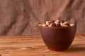 Deep fried peanuts in clay bowl over rustic wicker background. Selective focus Royalty Free Stock Photo