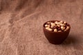 Deep fried peanuts in clay bowl over rustic wicker background. Selective focus Royalty Free Stock Photo