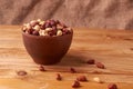 Deep fried peanuts in clay bowl over rustic wicker background. Selective focus Royalty Free Stock Photo
