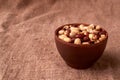 Deep fried peanuts in clay bowl over rustic wicker background. Selective focus Royalty Free Stock Photo