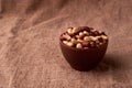 Deep fried peanuts in clay bowl over rustic wicker background. Selective focus Royalty Free Stock Photo