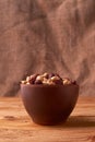 Deep fried peanuts in clay bowl over rustic wicker background. Selective focus Royalty Free Stock Photo