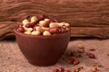 Deep fried peanuts in clay bowl over rustic wicker background. Selective focus Royalty Free Stock Photo