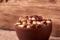 Deep fried peanuts in clay bowl over rustic wicker background. Selective focus Royalty Free Stock Photo