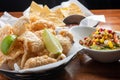 Pork Rinds Also Called Chicharron Or Chicharrones, Guacamole With Diced Fruits On Top  And Tortilla Chips With Salsa