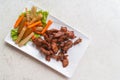 Deep fried pork with sesame in beautiful white plate, side dish with pickle vegetables and fresh vegetable on white stone table,