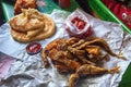 Deep fried sardine lies on oiled paper and near lies pickled olives, tomato sauce and flatbread Royalty Free Stock Photo