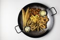 Deep fried set made from french fries, onion rings, big and small fried fish served in a wok over white background. Royalty Free Stock Photo