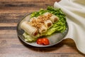 Deep fried Shrimp Spring Rolls with lettuce leaf and tomato served in dish isolated on wooden table top view of hong kong fast Royalty Free Stock Photo