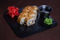 Deep-fried sushi roll with soy sauce and wasabi on a black stone plate Royalty Free Stock Photo