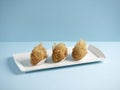 deep-fried taro puff with diced chicken served in a dish isolated on wooden board side view on grey background