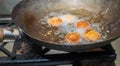 Deep frying falafel balls in wok, hot cooking oils bubbling and falafel balls turned golden brown color