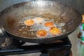 Deep frying falafel balls in a wok, hot cooking oils bubbling, and falafel balls turned a golden brown color