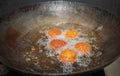 Deep frying falafel balls in a wok, hot cooking oils bubbling, and falafel balls turned golden brown color