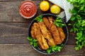 Deep frying small fish capelin in a pan on a dark wooden background. Royalty Free Stock Photo