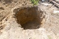 a deep hole is dug in the ground, a sinkhole in the ground Royalty Free Stock Photo