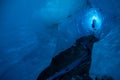 Deep narrow ice cave in the Matanuska Glacier of Alaska. Blue ice glowing deep beneath the surface of the glacier Royalty Free Stock Photo