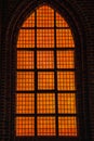 Deep orange light coming from a church is Gothic window conveys a diabolic, hellish and evil feeling with wicked and cruel concept