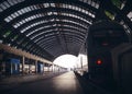 Deep perspective of rails and a train at Milan central station.