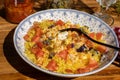 Deep plate on a wooden table with a homemade shredded chicken, rice and tomato salad. Healthy, natural, fresh food concept