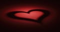 Deep red surface illuminated by a spotlight, casting a heart shadow Royalty Free Stock Photo