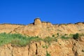 Deep sandy cliff on the background of blue sky.