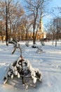 Deep snow in the city park with a church and a fir-tree covered with snow, sunny winter day Royalty Free Stock Photo