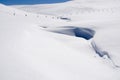 Snow Berm on a hillside with a half-buried fence paralleling the blue sky