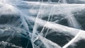 Deep wide white cracks on the dark ice of the frozen lake Baikal in Russia. Travel to winter Baikal