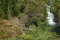 deepblue pool and green forest with waterfalling over stones