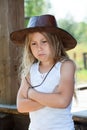 Deeply offended young girl, dressed cowboy leather hat and white shirt, crossed arms, purse lips Royalty Free Stock Photo